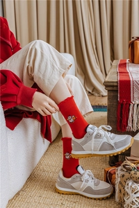 Detail of red festive cotton crew socks featuring maneki-neko embroidery and lucky motifs