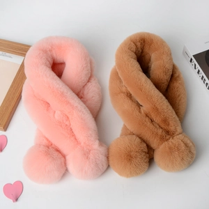 Detailed view of plush faux rabbit fur scarves with pom-poms in pink and brown tones