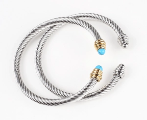 Detailed view of cable twist cuff bracelets in silver and gold with turquoise ends