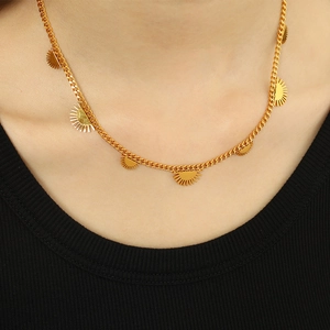 Elegante Halskette aus goldfarbenem Titanstahl mit Sonnenstrahl-Anhänger an einem Model