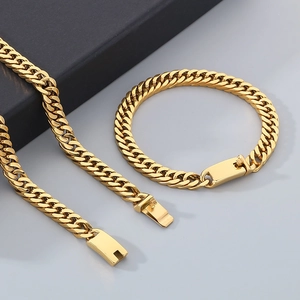 Close-up of golden stainless steel cuban chain necklace and bracelet set with box clasps