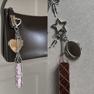 Close-up of heart-shaped carabiner and silver mesh lipstick pouch keychain accessory