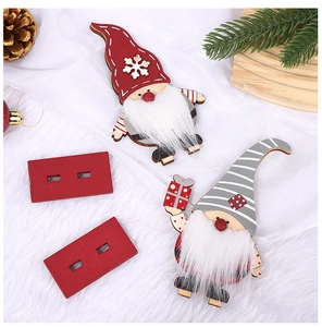 Detail of wooden Santa Claus figures with red and grey hats on festive white fur background