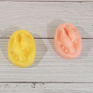 Détail du relief 3D dauphin sur des moules ovales en silicone jaune et orange pour savon