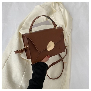 Détail du sac à main en cuir PU marron avec fermoir doré en forme de galet et fini texturé
