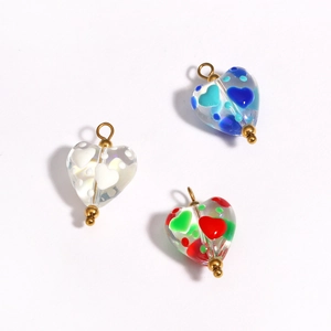 Detailed view of heart-shaped glass beads with colorful accents and golden metal loops