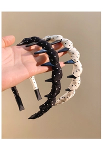 Detail of white and black polka dot headbands with unique spiked edge design
