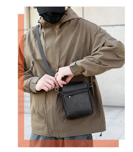Close-up of black PU leather crossbody bag with adjustable wide strap on male model