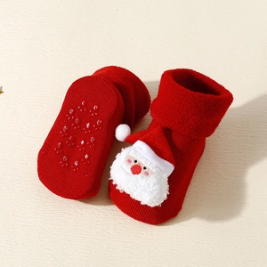 Detail of red Christmas baby socks with 3D Santa decor and non-slip silicone grip soles