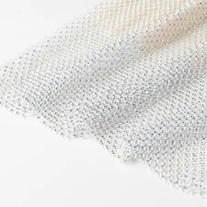 Détail macro de strass scintillants sur une robe de soirée en maille argentée de qualité