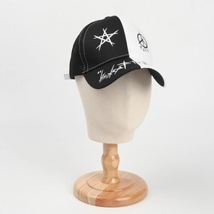 Close-up of black and white graffiti baseball cap with star print on a wooden stand