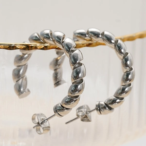 Polished silver stainless steel twist hoop earrings with a textured c-shape design