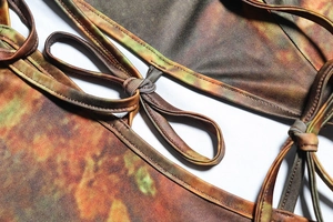 Détail de l'imprimé tie-dye terreux et du laçage sur cette robe en maille vintage