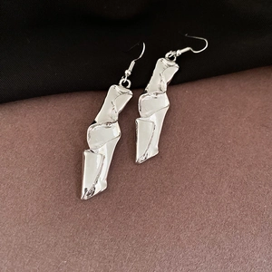 Detail of silver long drop earrings with irregular liquid metal texture and wrinkles