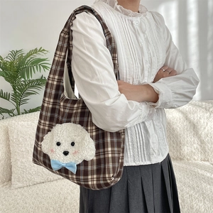 Detail of brown plaid tote bag with plush puppy embroidery and blue silk bow accent