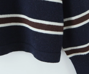Detailed macro view of the contrast stripe knit texture and hem of the POLO sweater