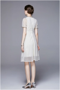 Rear view of white lace midi dress featuring intricate embroidery and beaded edges