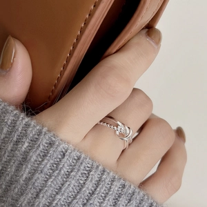 Detail of 925 sterling silver double-row knot ring with beaded chain and smooth band