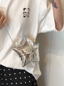 Detail of silver star-shaped acrylic crossbody bag with rhinestone tassels on a model