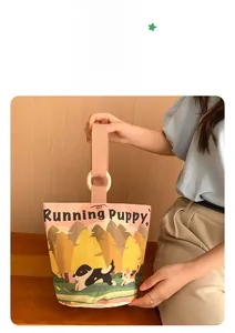 Detail of pink canvas bucket bag featuring a running puppy illustration and woven handles