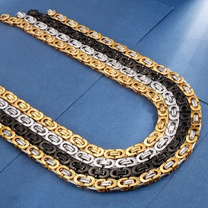 Close-up of Byzantine chain necklaces in gold, silver, and black stainless steel