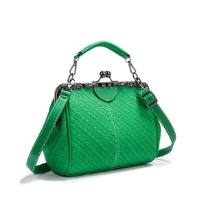 Detail of green woven texture PU leather handbag with vintage metal clasp and chain