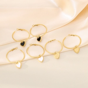 Gold stainless steel hoop earrings with black and white enamel heart charms on silk