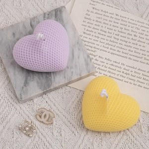 Woven heart scented candles in purple and yellow on marble coaster for home decor