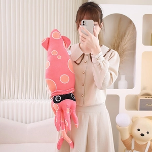 Pink giant squid plush toy held by a model in a cozy, modern home living room setting