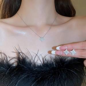 Close-up of starburst necklace and matching earrings set with sparkling stones on model
