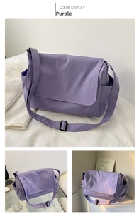Detail view of purple nylon messenger bag with wide shoulder strap and side pockets
