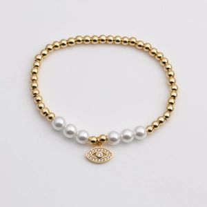 Golden beaded bracelet with pearls and a sparkling cubic zirconia evil eye pendant