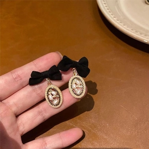 Détail de boucles d'oreilles vintage en velours noir avec perles et cristaux dorés