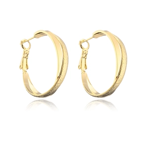 Close-up of gold plated twisted hoop earrings with textured and smooth finishes