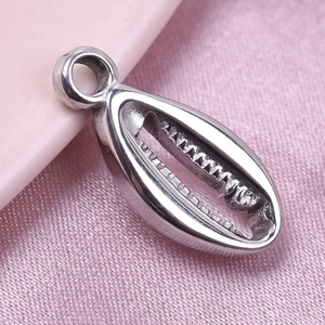 Détail d'un pendentif en forme de coquillage en acier inoxydable 304 sur tissu rose