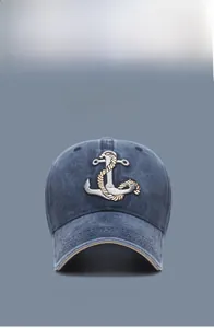 Detailed close-up of navy washed cotton baseball cap with anchor embroidery and curved brim