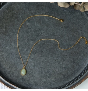 Close-up of teardrop green aventurine pendant on 18K gold-plated titanium chain