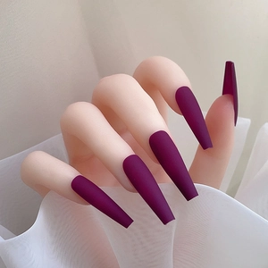 Gros plan d'ongles longs coffin violet foncé mats à presser sur une main mannequin