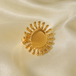 Detail of 18k gold plated sunflower ring resting on elegant cream satin fabric background