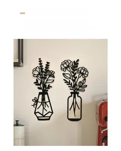 Dettaglio decorazione murale in metallo nero con design minimalista di vaso e fiori in 2 pezzi