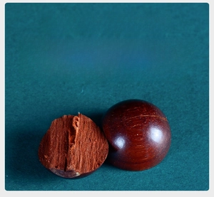 Macro shot showing internal wood fiber texture and mineral deposits of sandalwood bead