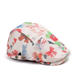 Detail of cream canvas flat cap featuring colorful cartoon prints and vintage side buckles