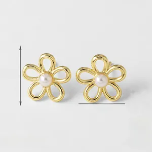 Detail macro-opname van 14mm gouden bloemoorbellen met elegante witte parels in het midden