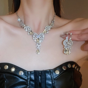 Detail view of a sparkling silver waterdrop necklace and earring set on a model