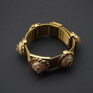 Macro detail of vintage gold mesh bracelet with inlaid cream pearl and zircon stones