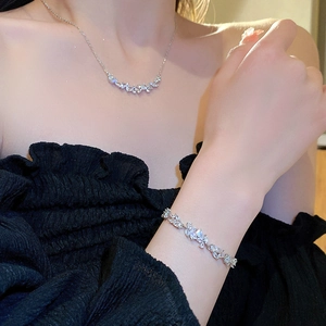 Close-up of floral cubic zirconia necklace and bracelet set worn on a model's neck