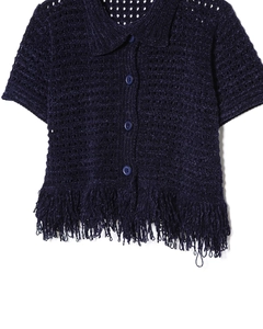 Dettaglio del cardigan in maglia blu scuro con orlo a frange e design del collo a rever