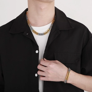 Hip hop two-tone Cuban link chain necklace and bracelet set worn by a male model