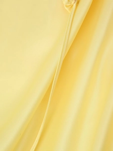Gros plan sur la texture du satin jaune montrant les coutures et le tissage détaillés