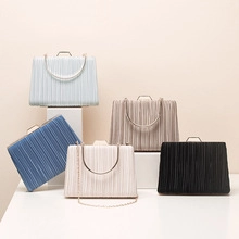 Various colored glitter evening clutch bags with round metal handles on white pedestals